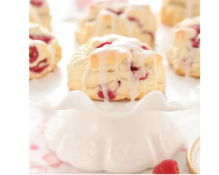 Delicious Lemon Raspberry Scones with fresh raspberries and lemon zest on a plate.