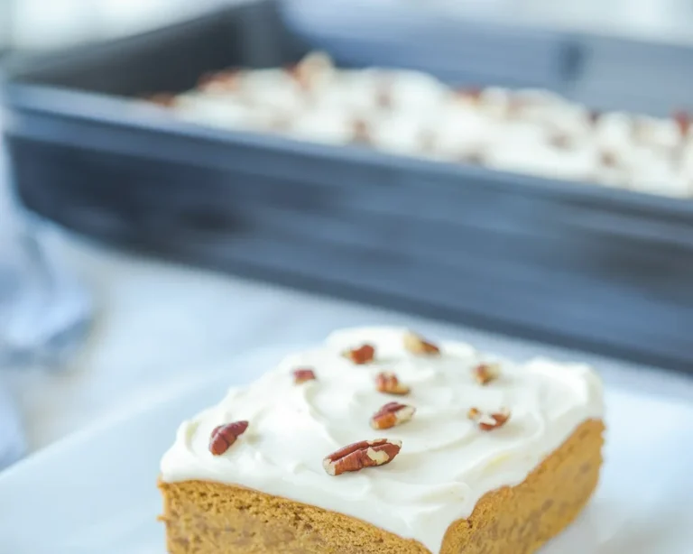 Slice of Keto Pumpkin Cake with cream cheese frosting on a plate