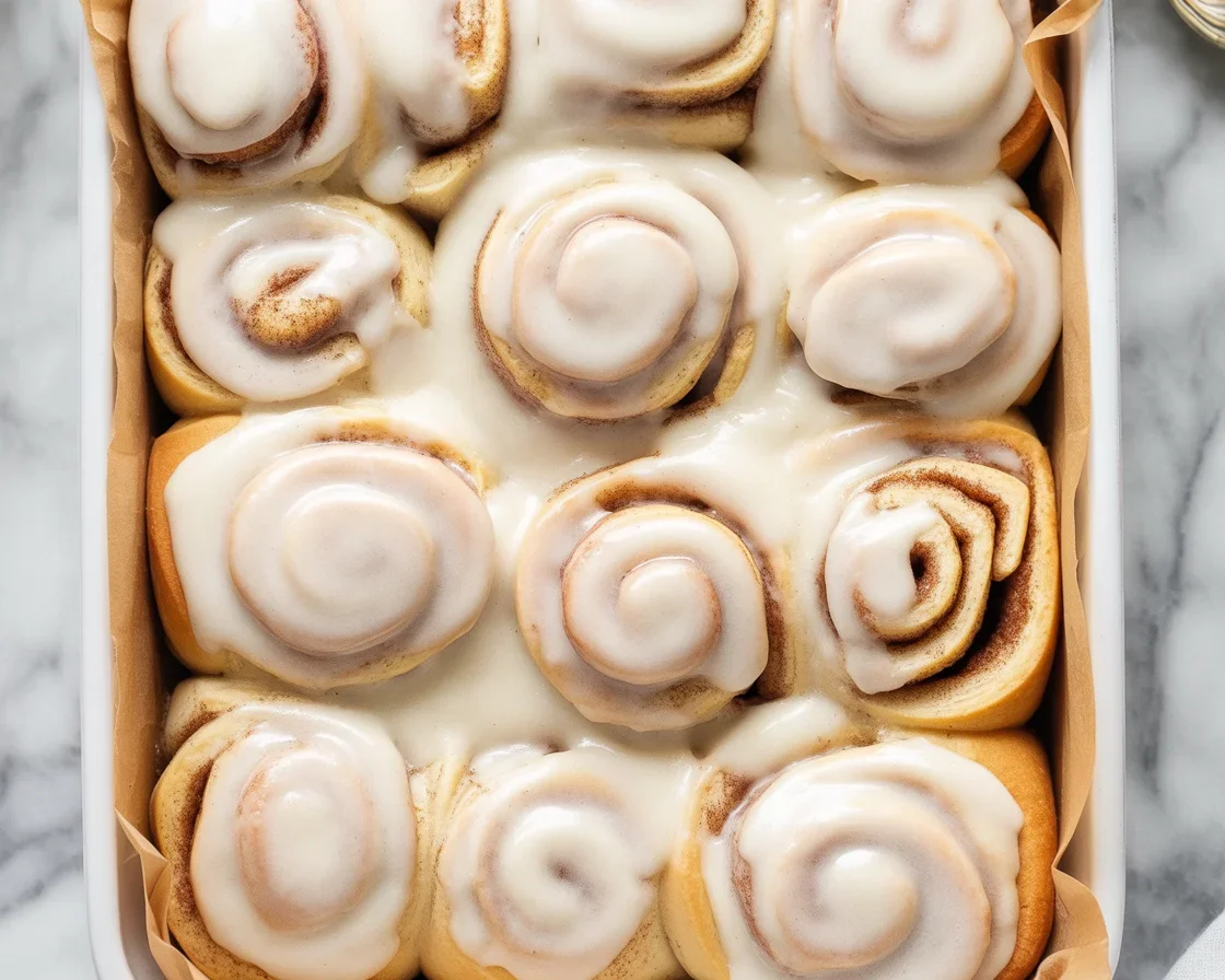 Delicious Vegan Cinnamon Rolls topped with creamy icing, soft and fluffy texture.